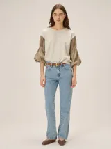 Remera combinada con cuerpo de tejido liso en tono crudo y mangas abullonadas en color marrón con textura liviana y frunces.