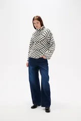 Sweater de lana con diseño jacquard geométrico en blanco y negro, de corte holgado, cuello alto y mangas largas.