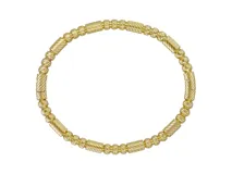 Esclava rígida de acero con baño de oro, compuesta por una alternancia de esferas texturadas y cilindros estriados.