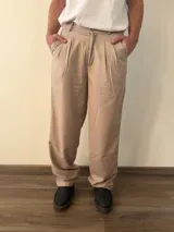 Pantalón sastrero de corte recto con pinzas frontales y traseras, cintura con elástico en la parte posterior y bolsillos laterales.