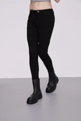 Pantalon skinny de tiro medio, confeccionado en tejido de algodón con elastano, con cierre frontal y bolsillos laterales.