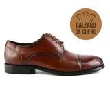 Zapato de vestir acordonado de cuero negro, con puntera ligeramente redondeada.