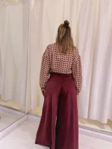 Pantalón de terciopelo color borgoña, de tiro medio y corte acampanado.