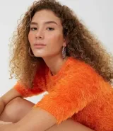 Blusa naranja de manga corta con textura de peluche sintético.