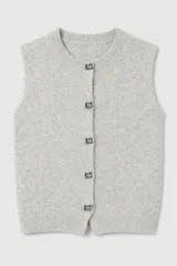 Chaleco de punto gris con textura suave y sutiles destellos brillantes. Presenta cuello redondo, cierre frontal con botones decorativos de estilo joya y diseño sin mangas.