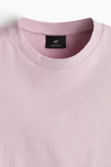 Remera de manga corta color lila claro, con cuello redondo ribeteado y corte estándar.