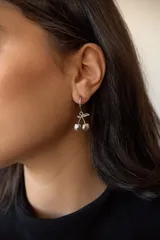 Aros de acero quirúrgico hipoalergénico, con argolla pequeña y dije colgante en forma de cerezas.