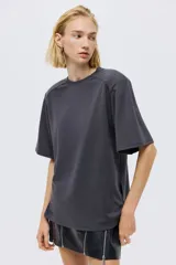 Remera gris oscuro de manga corta con cuello redondo y costuras oblicuas en los hombros.