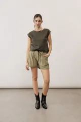 Short blanco de tiro alto, confeccionado en lino, con bolsillos laterales y cordón ajustable en la cintura.