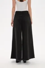Pantalon de jean azul de corte ancho y tiro alto, con ruedo deshilachado.