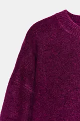 Jersey de punto con cuello redondo y manga larga, confeccionado en un suave tejido color bordó.