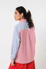 Camisa a rayas rojas y blancas en un lado y azules y blancas en el otro, con corte en A y abertura central con botonadura doble.