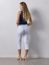 Pantalón capri blanco de gabardina elastizada. Pretina ancha elastizada, delantera con bolsillos simulados y trasera con bolsillos aplicados.