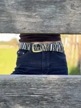 Cinturón con estampado animal print de cebra, hebilla metálica dorada y presilla móvil.