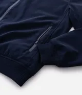 Campera estilo bomber de color negro, confeccionada con tejido repelente al agua. Posee cuello semi alto, cierre frontal con cremallera, bolsillos laterales y puños y dobladillo elastizados. Marca Marfinno.