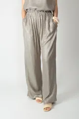 Pantalón de pierna amplia color plateado con acabado metalizado, cintura elástica fruncida y bolsillos laterales.