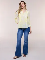 Blusa celeste con estampado efecto pincelada blanca, de corte semi holgado, escote en V con cuello solapa y media abotonadura frontal con botones nacarados. Presenta finas alforzas verticales en la pechera y mangas 3/4 con puños elastizados.