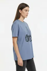 Remera de algodón color beige con estampado frontal de un corazón rosado que contiene un moño. Tiene cuello redondo y mangas cortas.
