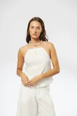 Top blanco de lino con breteles finos elásticos regulables en la espalda y fruncido en el escote y la espalda.