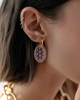 Dije colgante para aro con forma ovalada, borde de acrílico espejado rosado y centro de resina con estampado de flores pequeñas.