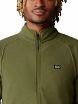 Campera polar verde militar con cierre frontal completo, cuello alto y bolsillos laterales con cierre. Confeccionada en tejido de vellón polar, cuenta con mangas raglán y pequeño logo de la marca bordado en el pecho.