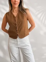 Chaleco sin mangas marrón de lino, con escote en V, botonera frontal y detalles de puntilla en los bordes.