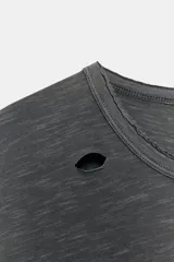 Camiseta de corte oversize confeccionada en algodón flamé, con cuello redondo y manga corta. Presenta un diseño con efecto desgastado, detalles de roturas en el tejido y estampado de texto a contraste en la parte frontal.