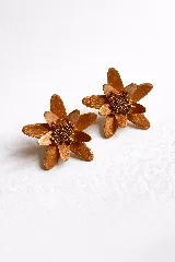 Par de aros dorados con forma de flor, con pétalos texturizados y centro de cuentas pequeñas.