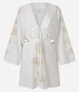 Vestido corto de playa confeccionado en voil de algodón BCI color blanco, con escote en V con lazo, cutouts laterales, mangas largas y bordados de caracoles de mar.