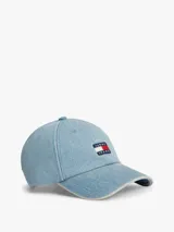 Gorra de béisbol Tommy Jeans de estilo vintage, confeccionada en tejido denim de algodón con efecto desteñido en los bordes y costuras. Cuenta con diseño de seis paneles, ojales de ventilación, visera curva con costuras texturizadas, hebilla de ajuste metálica en la parte trasera y parche con el logo de la marca en el frente.