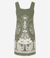 Vestido corto color verde militar con escote cuadrado, breteles anchos y sin mangas. Presenta un diseño estampado floral en color blanco de estilo simétrico y detalle de cenefa en el ruedo.