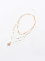 Collar dorado de tres hilos con dijes colgantes en forma de lágrima y un dije central con diseño calado.