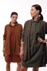 Chaleco de diseño fluido con escote cruzado y lazo ajustable en la cintura. Presenta un corte largo y versátil, ideal para superponer en diferentes looks.