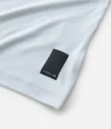 Remera deportiva de hombre con tecnología dry fit, cuello redondo y manga corta. Presenta un diseño liso en color beige con una pequeña etiqueta decorativa en el dobladillo.