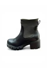 Bota negra de caña corta con elástico en los laterales, suela track y taco cuadrado.