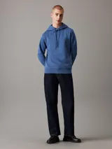 Buzo con capucha Calvin Klein color azul, de felpa de algodón y poliéster. Tiene corte regular, puños y bajo de canalé, capucha con cordón y logo bordado en el pecho.