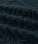 Buzo de cuello redondo y manga larga, confeccionado en tejido de poliéster con textura de cuerdas en relieve y puños acanalados.