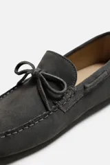 Mocasín casual fabricado en piel con acabado serraje, con detalle de lazo en el empeine y horma redonda.