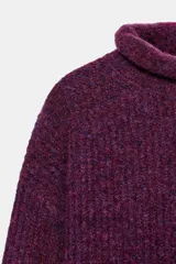 Jersey de punto con textura, cuello subido y manga larga, de corte recto y diseño clásico.