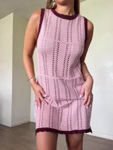 Vestido corto de tejido de punto color marrón con detalles calados en franjas verticales y horizontales, cuello redondo y ribetes blancos en contraste.