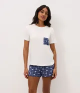 Pijama corto de dos piezas de la marca Lov, confeccionado en viscolycra. Incluye una remera blanca de manga corta, cuello redondo y un bolsillo frontal a cuadros, combinada con un short azul marino con estampado a cuadros y diseño de osos, con cintura elástica.