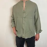 Camisa de manga larga con cuello mao, confeccionada en lino, con corte regular y cierre frontal de botones.