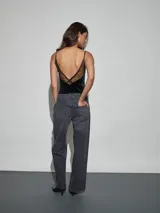 Body negro confeccionado en terciopelo, de corte ajustado, con tirantes finos y detalles de encaje transparente en el escote.