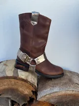 Bota de cuero marrón con estribo desmontable plateado.