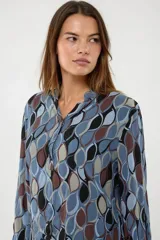 Camisa de manga larga con cuello mao y escote en V, confeccionada en algodón con un estampado geométrico abstracto en tonos azules, marrones, negros y beige.