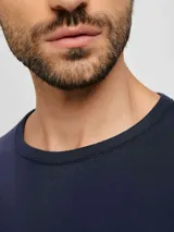 Camiseta azul de manga larga, cuello redondo y corte clásico.