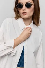 Camisa de algodón blanca de calce relajado, con cuello clásico, mangas largas y cierre frontal con botones.