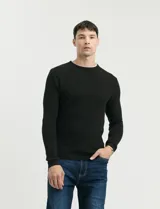 Sweater de punto con textura tipo waffle, color negro, de corte clásico con cuello redondo y mangas largas.