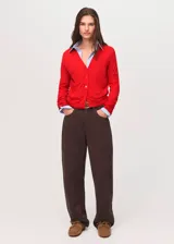 Cardigan de punto fino color rojo, con cuello en V, manga larga y cierre delantero con botones.