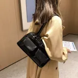 Cartera de hombro color negro, de diseño rectangular con dos bolsillos frontales con solapa y cierre principal superior.